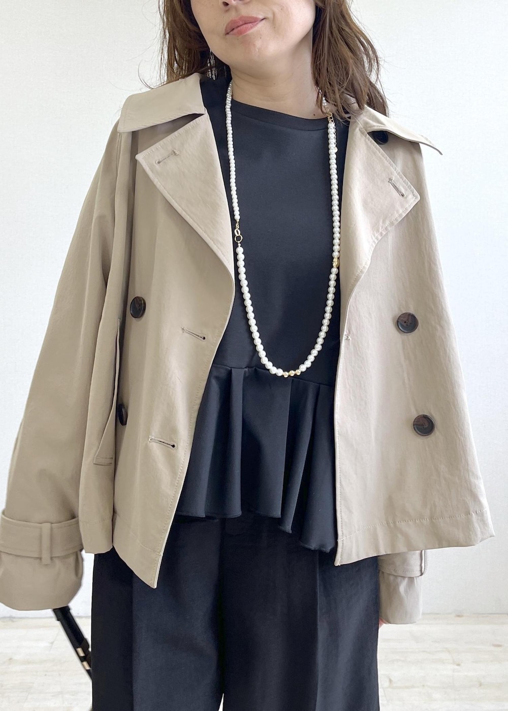 ブラック系のショルダーバッグ、ベージュ系のパンプス、ベージュ系のトレンチコートを着用したレディースの春コーディネートの5枚目の写真