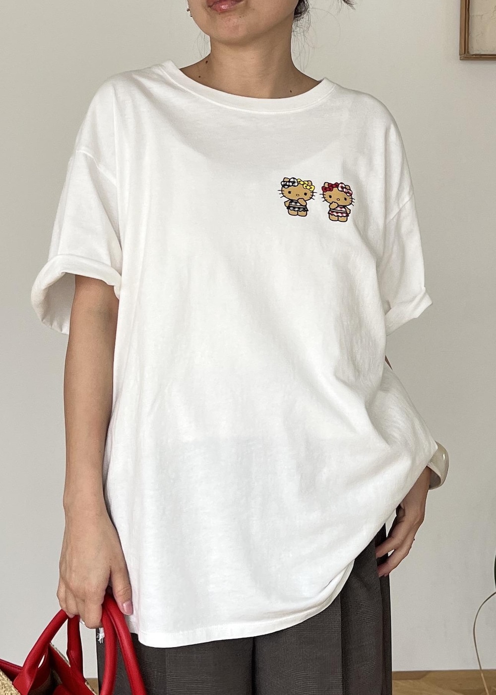 レッド系のトートバッグ、ホワイト系のTシャツ/カットソーを着用したレディースの夏コーディネートの5枚目の写真