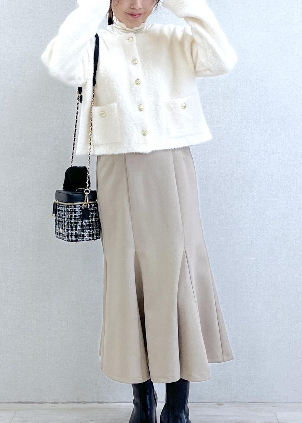 ベージュ系のスカート、ホワイト系のカーディガン/ボレロ、ホワイト系のTシャツ/カットソーを着用したレディースの秋コーディネートの4枚目の写真