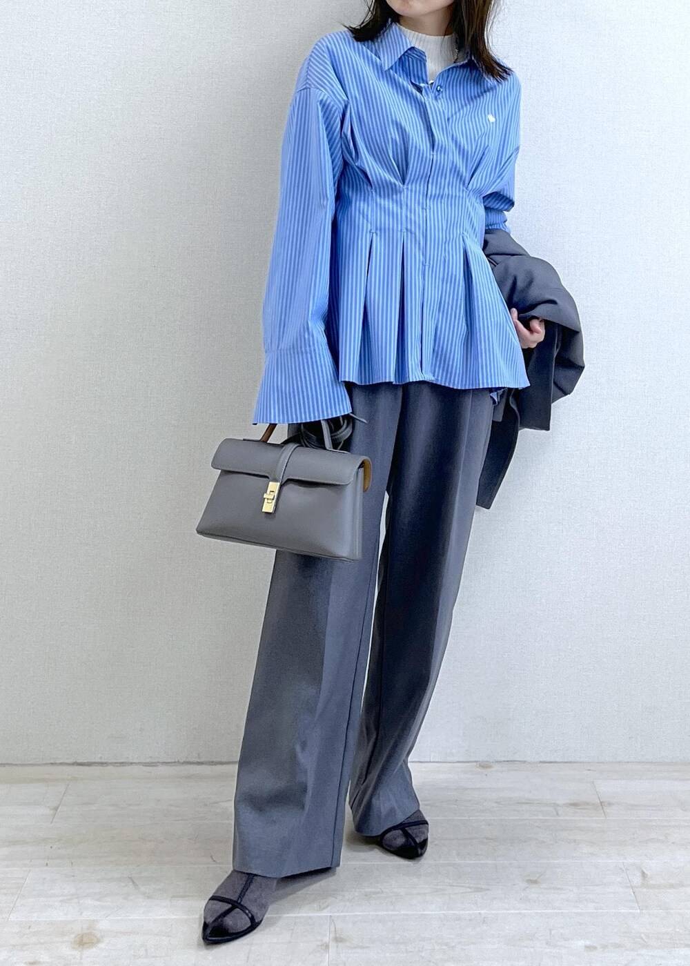 グレー系のショルダーバッグ、ブルー系のシャツ/ブラウス、ホワイト系のニット/セーターを着用したレディースの秋コーディネートの7枚目の写真