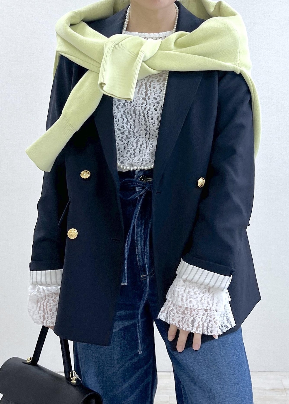 ブルー系のテーラードジャケット、グリーン系のカーディガン/ボレロ、ブルー系のデニムパンツを着用したレディースの冬コーディネートの6枚目の写真