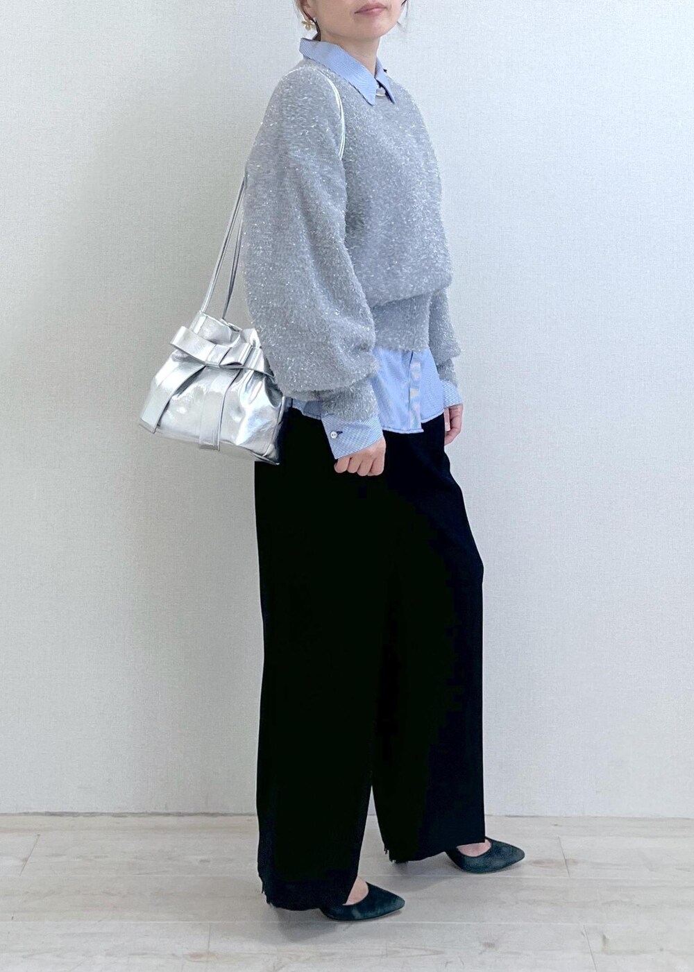 シルバー系のショルダーバッグ、ブラック系のスラックス、ブルー系のシャツ/ブラウスを着用したレディースの冬コーディネートの4枚目の写真