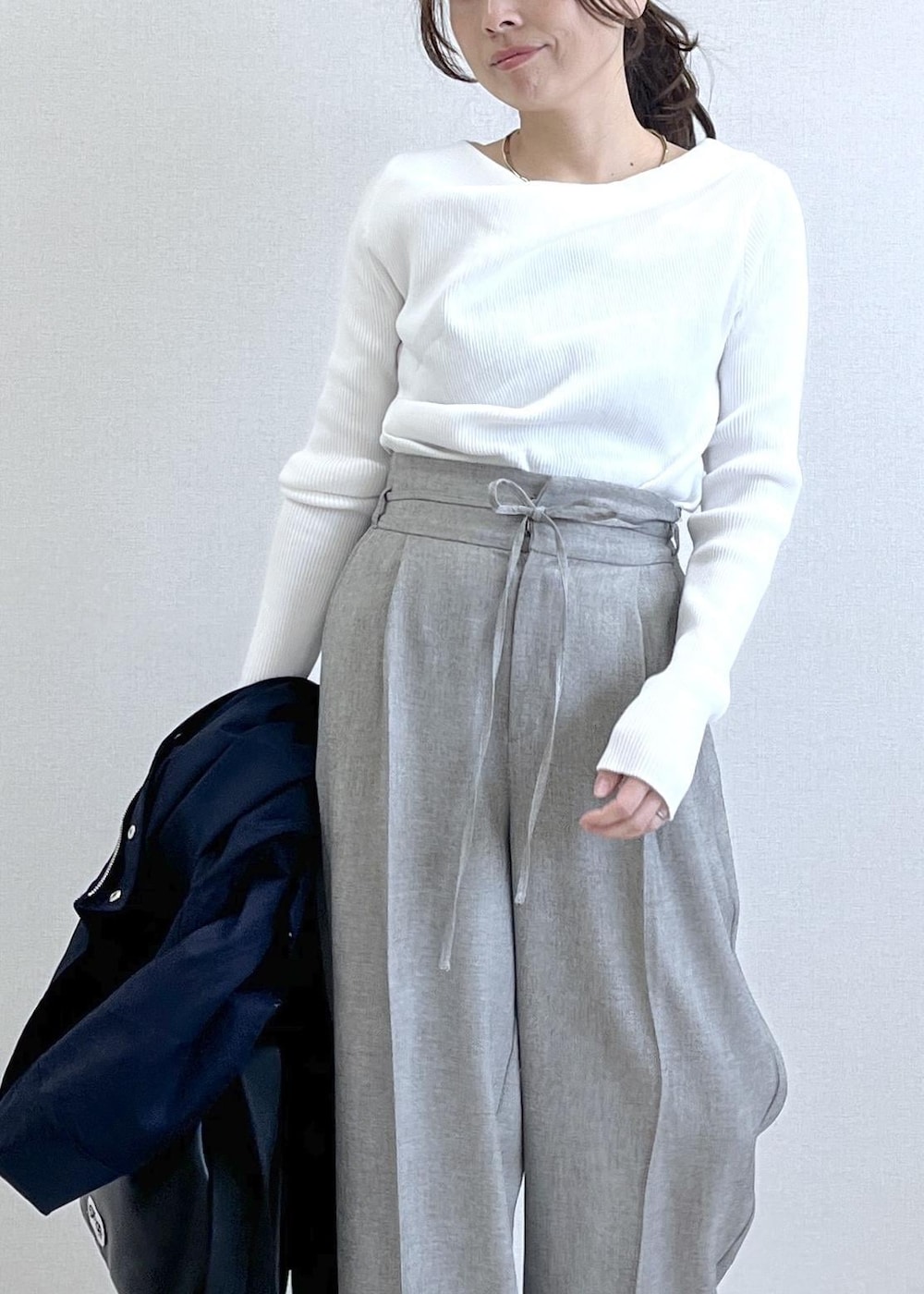 ブラック系のトートバッグ、ブルー系のナイロンジャケット、グレー系のその他パンツを着用したレディースの春コーディネートの9枚目の写真