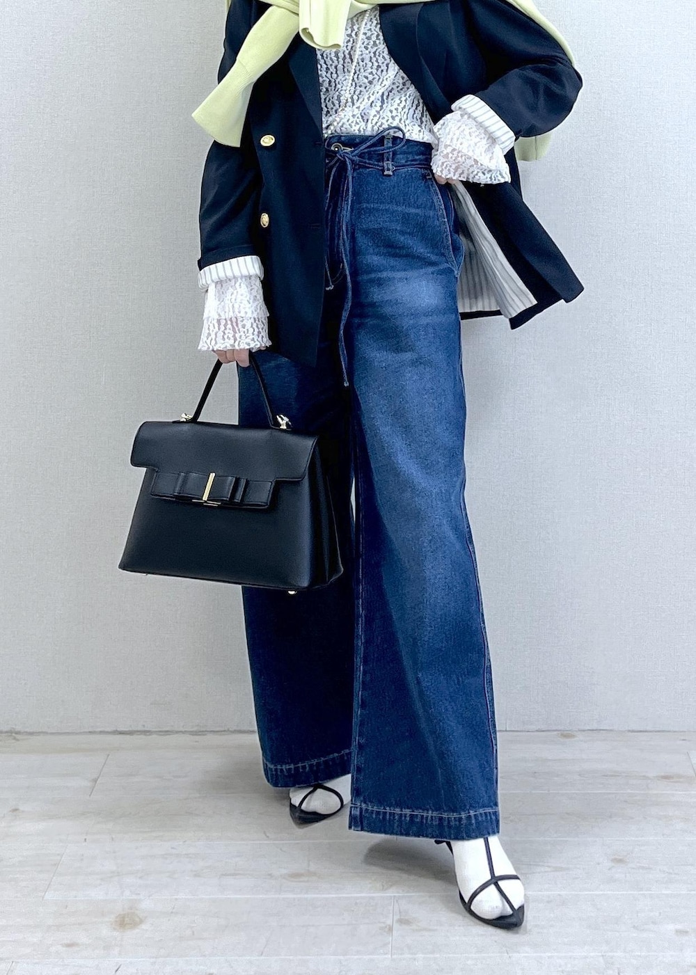 ブルー系のテーラードジャケット、グリーン系のカーディガン/ボレロ、ブルー系のデニムパンツを着用したレディースの冬コーディネートの2枚目の写真