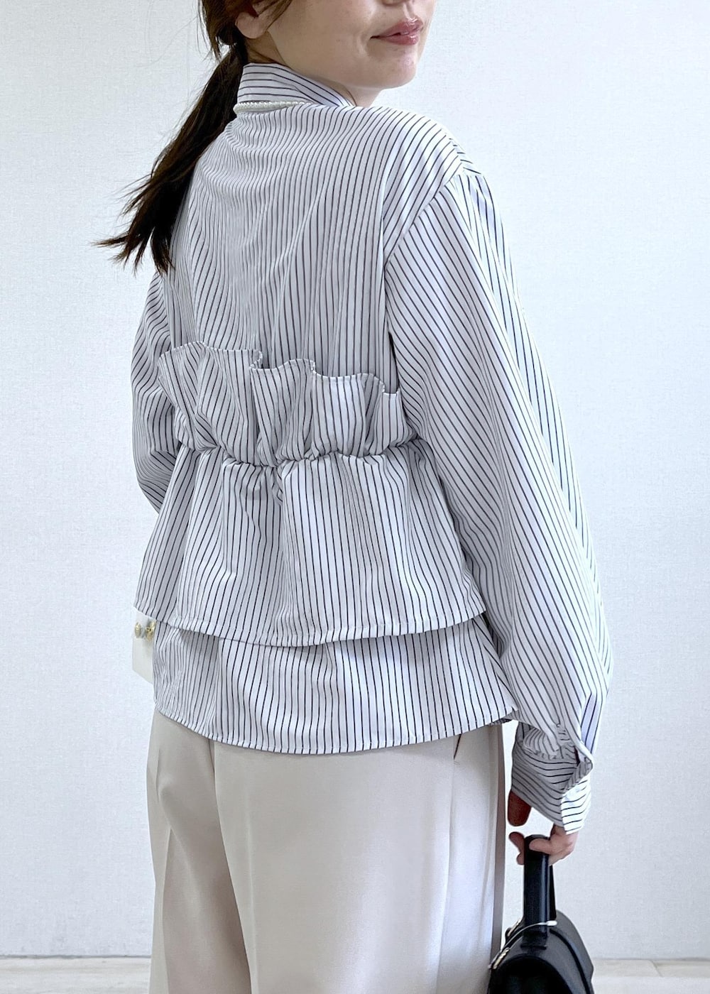 ブラック系のショルダーバッグ、グリーン系のテーラードジャケット、ベージュ系のその他パンツを着用したレディースの春コーディネートの8枚目の写真