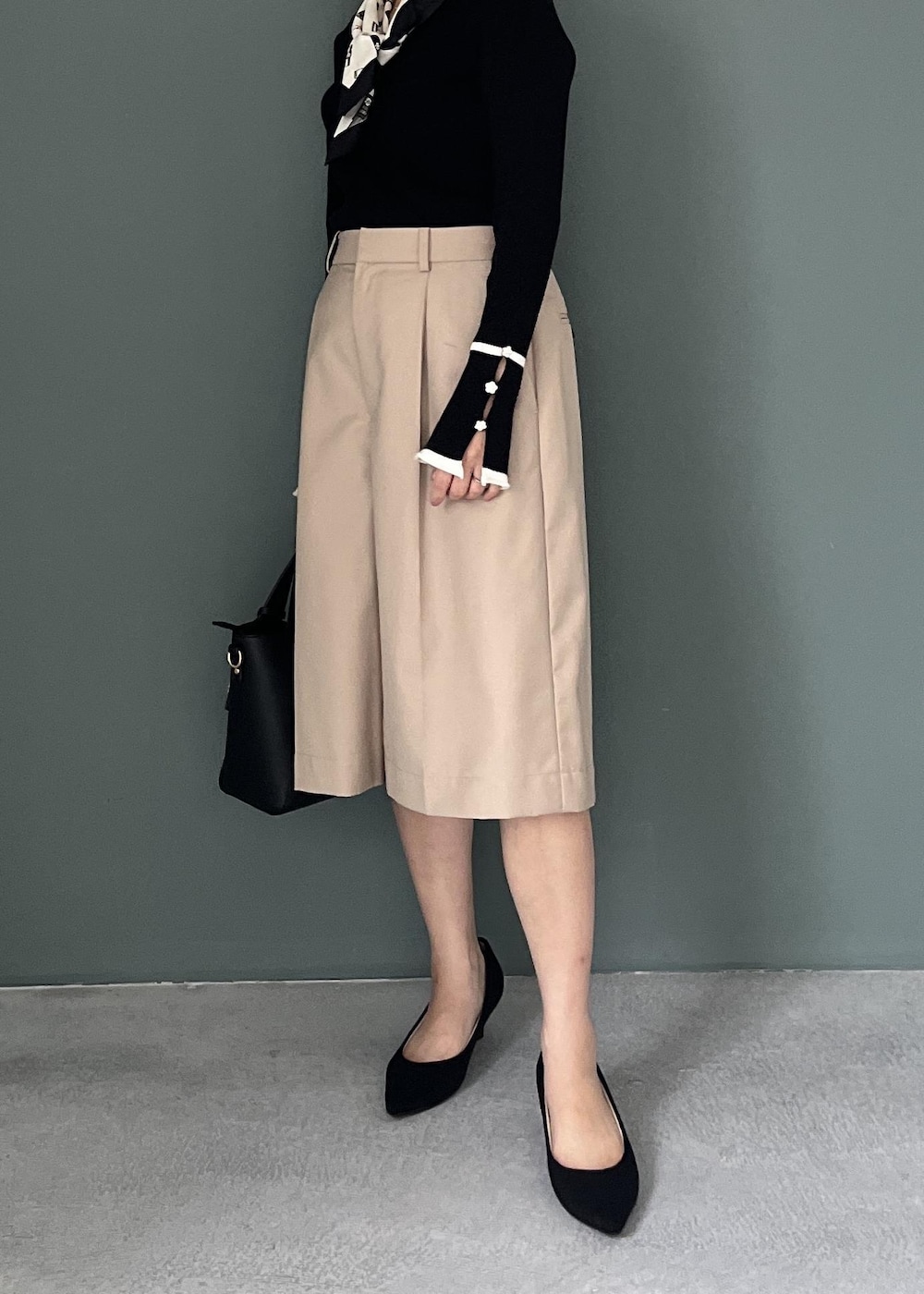 ベージュ系のその他パンツ、ブラック系のトートバッグ、ブラック系のニット/セーターを着用したレディースの秋コーディネートの6枚目の写真