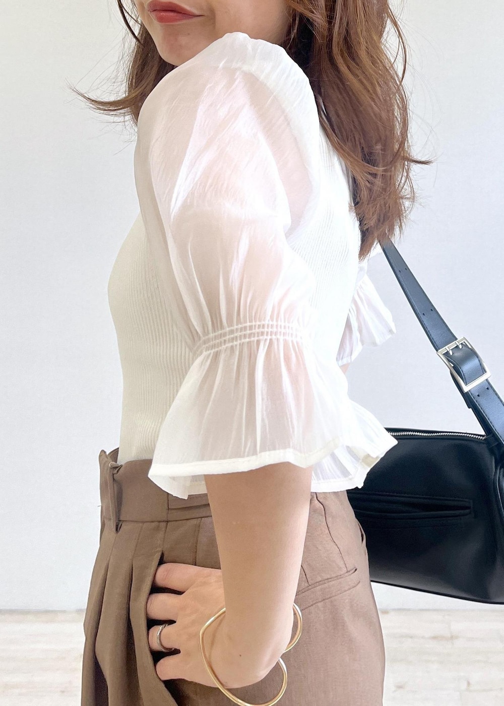 ブラック系のショルダーバッグ、ブラック系のサンダル、ブラウン系のテーラードジャケットを着用したレディースの夏コーディネートの5枚目の写真