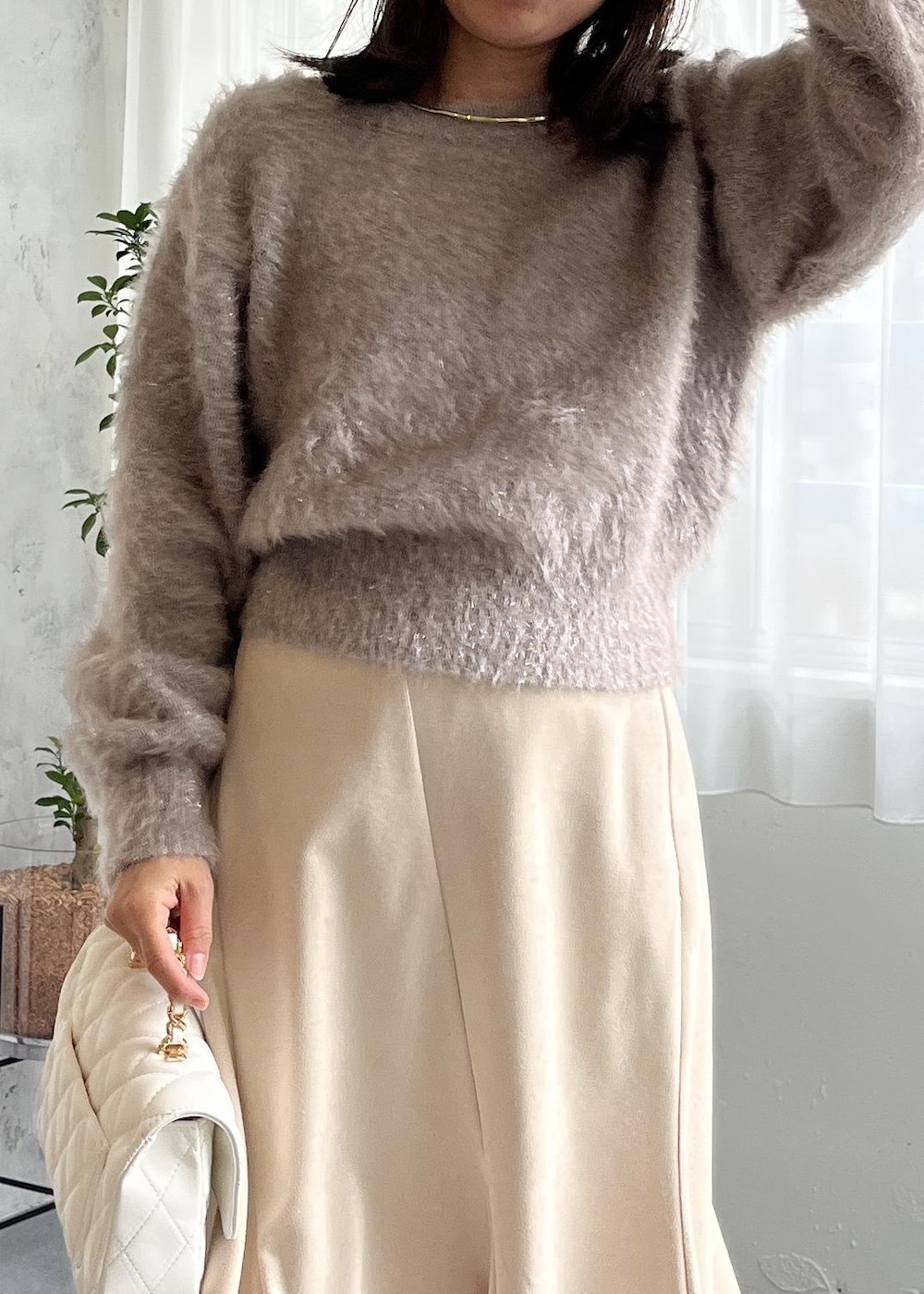 ブラウン系のブーツ、ホワイト系のスカート、ベージュ系のニット/セーターを着用したレディースの秋コーディネートの4枚目の写真