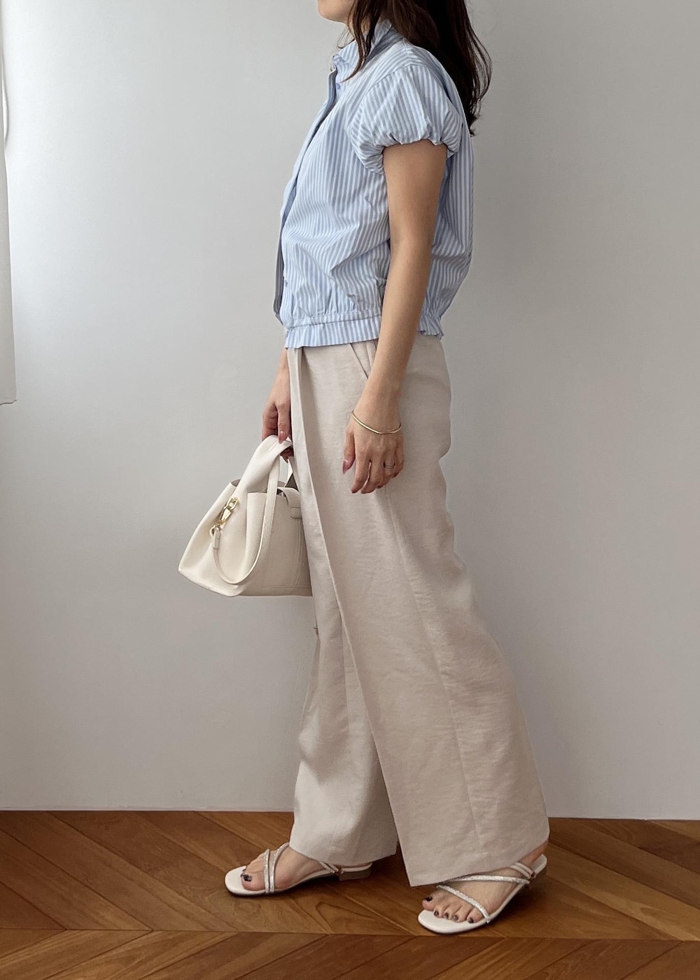 ホワイト系のその他パンツ、ホワイト系のショルダーバッグ、ホワイト系のサンダルを着用したレディースの春コーディネートの3枚目の写真