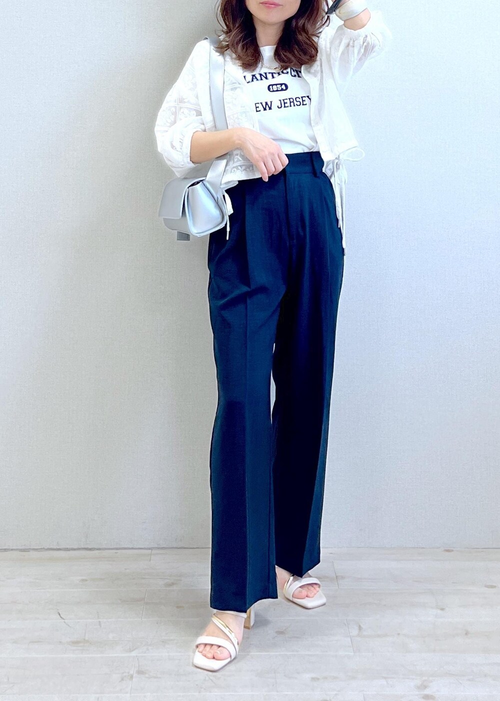 シルバー系のショルダーバッグ、ホワイト系のTシャツ/カットソー、ホワイト系のサンダルを着用したレディースの春コーディネートの6枚目の写真