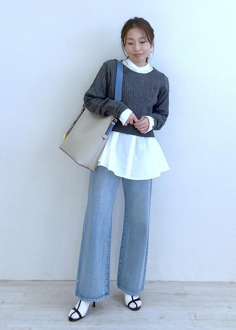 ベージュ系のショルダーバッグ、ホワイト系のシャツ/ブラウス、ブルー系のデニムパンツを着用したレディースの冬コーディネートの7枚目の写真