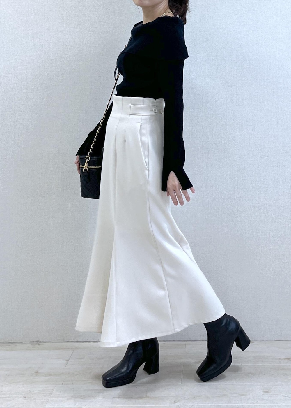 ブラック系のニット/セーター、ブラック系のダウンジャケット/コート、ブラック系のブーツを着用したレディースの冬コーディネートの2枚目の写真