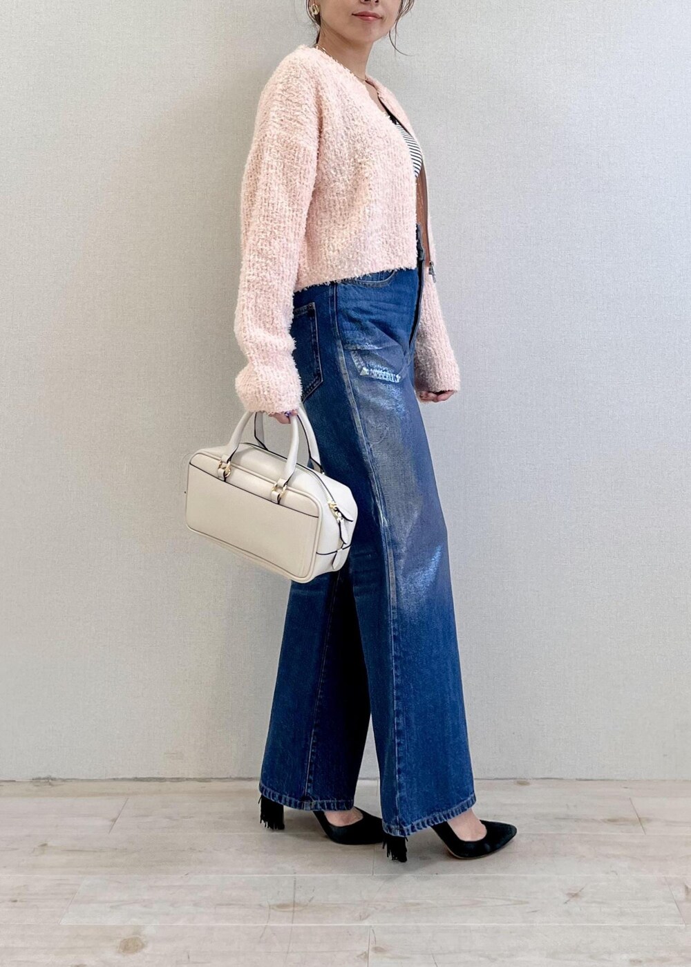 ピンク系のカーディガン/ボレロ、ブルー系のデニムパンツ、ホワイト系のボストンバッグを着用したレディースの冬コーディネートの3枚目の写真