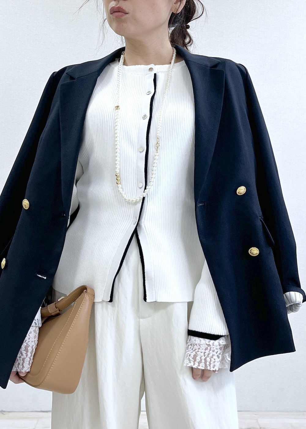 ブラック系のパンプス、ブルー系のテーラードジャケット、イエロー系のショルダーバッグを着用したレディースの冬コーディネートの5枚目の写真