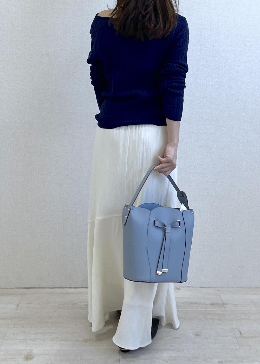 ブラック系のパンプス、ブルー系のショルダーバッグ、ベージュ系のトレンチコートを着用したレディースの春コーディネートの4枚目の写真