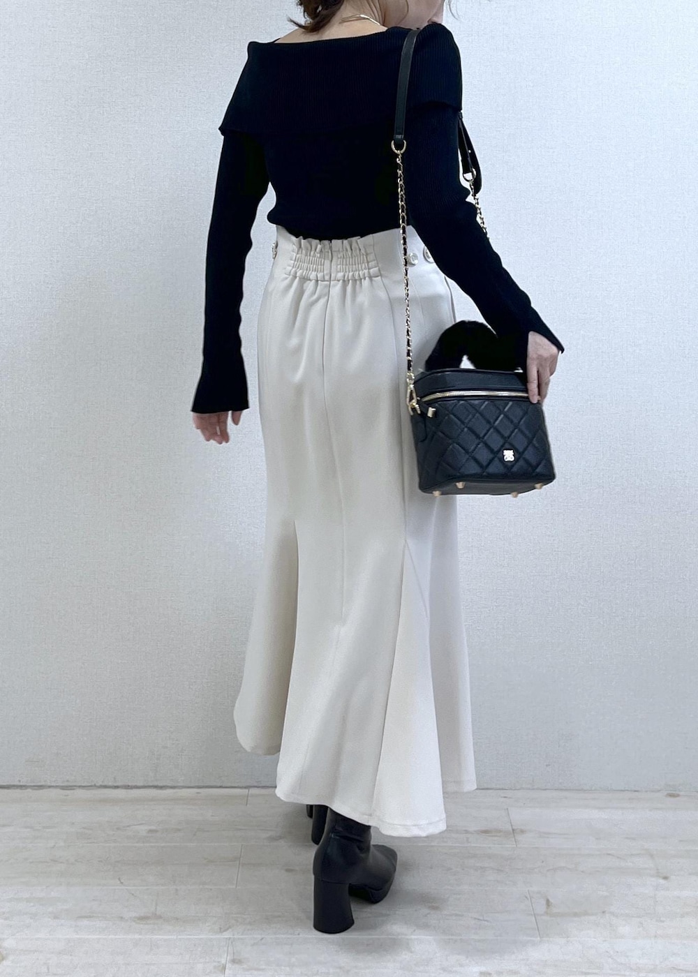 ブラック系のニット/セーター、ブラック系のダウンジャケット/コート、ブラック系のブーツを着用したレディースの冬コーディネートの4枚目の写真