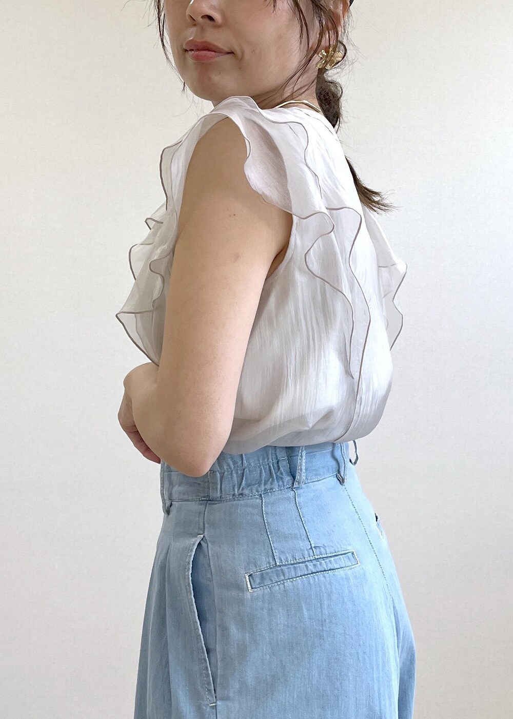 ホワイト系のサンダル、シルバー系のハンドバッグ、ブルー系のデニムパンツを着用したレディースの夏コーディネートの6枚目の写真