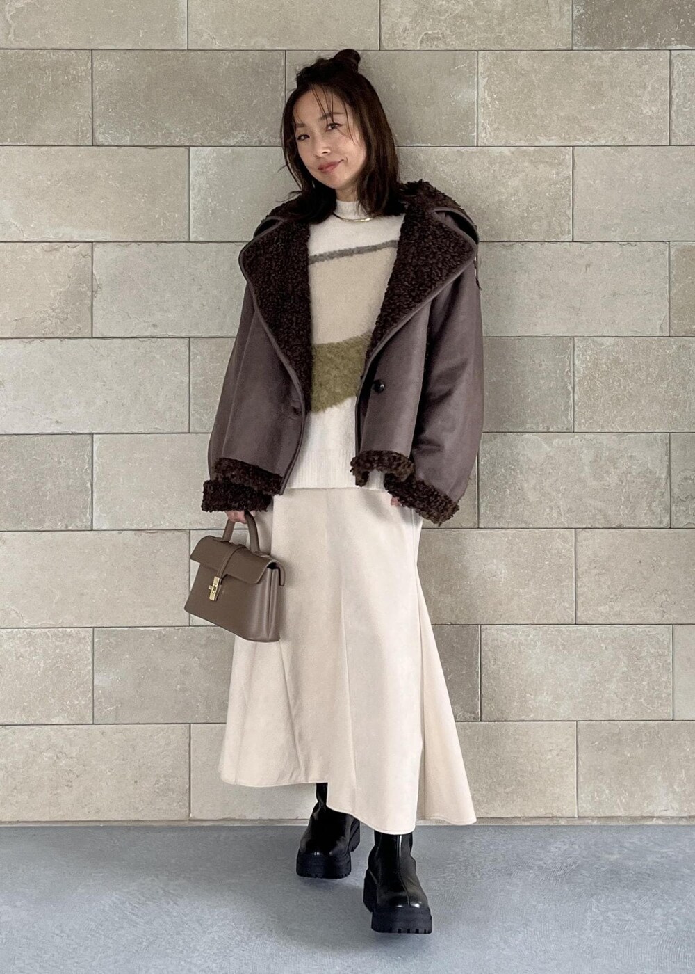 ベージュ系のショルダーバッグ、ブラック系のブーツ、ブラウン系のブルゾンを着用したレディースの秋コーディネートの7枚目の写真