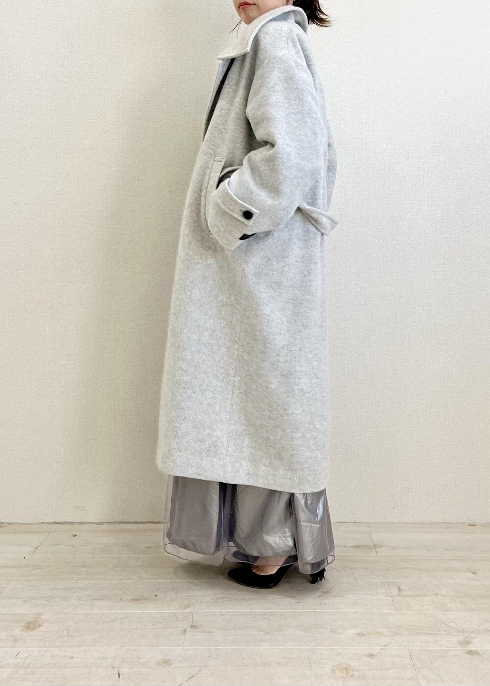 グレー系のその他アウター、グリーン系のニット/セーター、ブラック系のショルダーバッグを着用したレディースの冬コーディネートの2枚目の写真