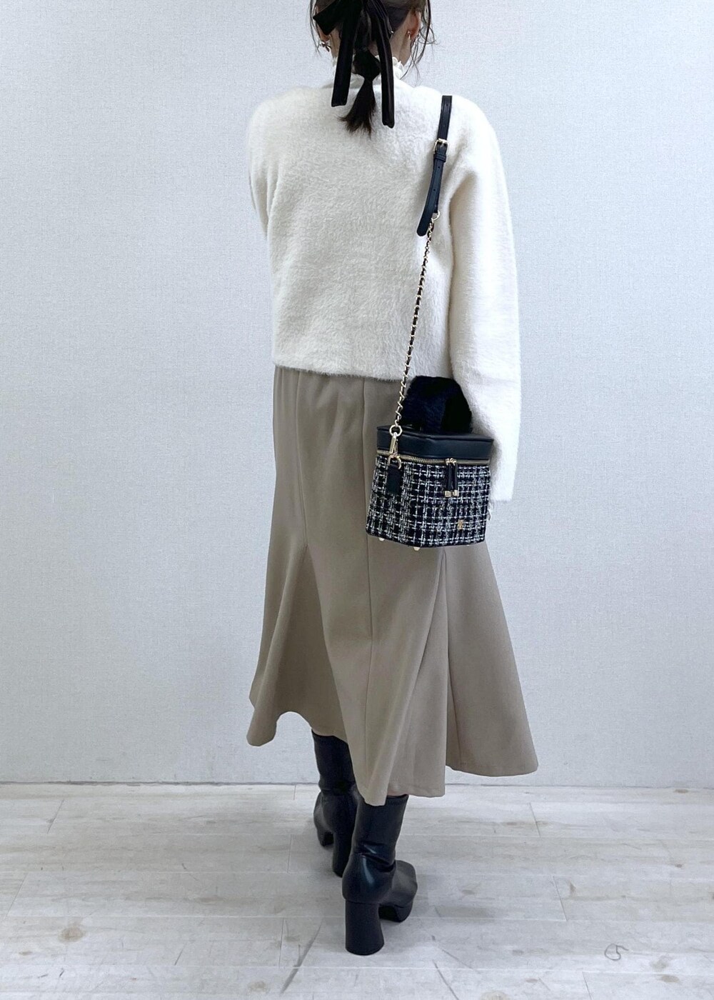 ベージュ系のスカート、ホワイト系のカーディガン/ボレロ、ホワイト系のTシャツ/カットソーを着用したレディースの秋コーディネートの5枚目の写真