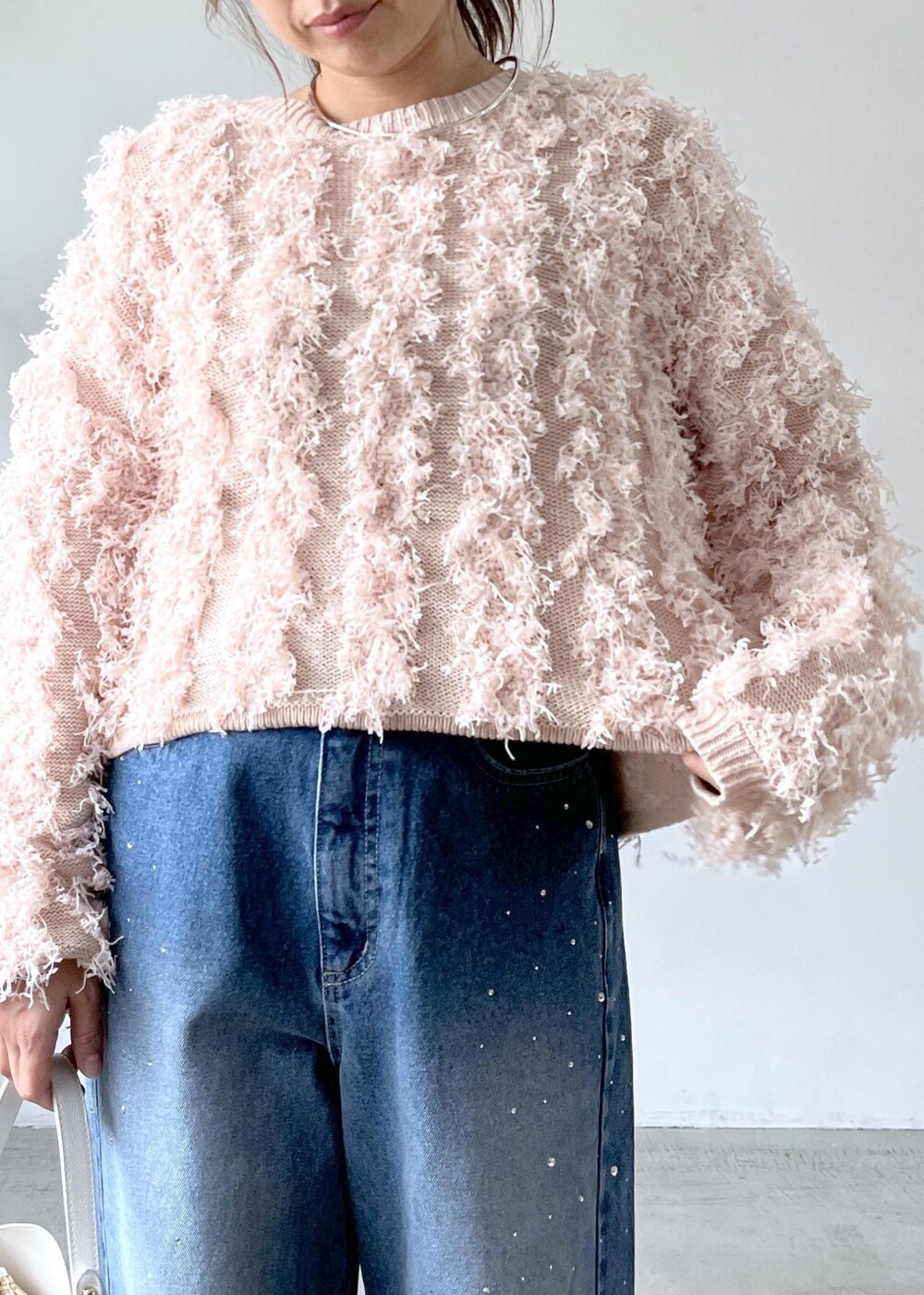 ホワイト系のショルダーバッグ、ベージュ系のブーツ、ピンク系のニット/セーターを着用したレディースの秋コーディネートの6枚目の写真