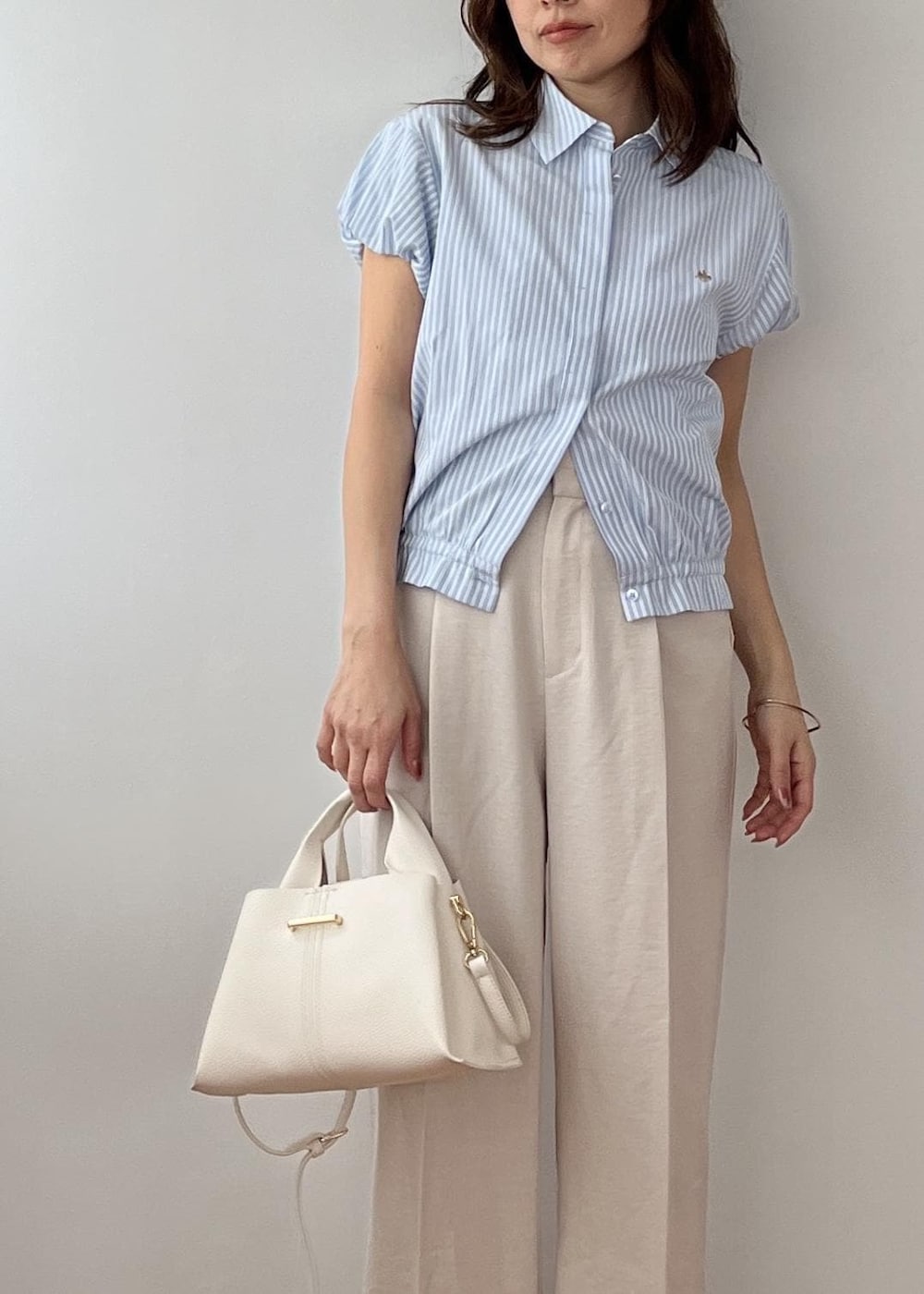 ホワイト系のその他パンツ、ホワイト系のショルダーバッグ、ホワイト系のサンダルを着用したレディースの春コーディネートの5枚目の写真