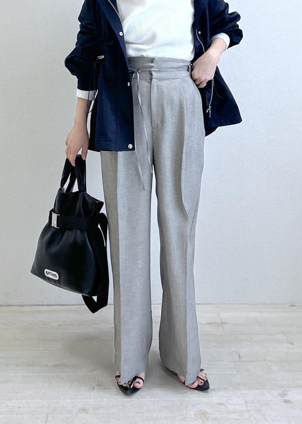 ブラック系のトートバッグ、ブルー系のナイロンジャケット、グレー系のその他パンツを着用したレディースの春コーディネートの10枚目の写真