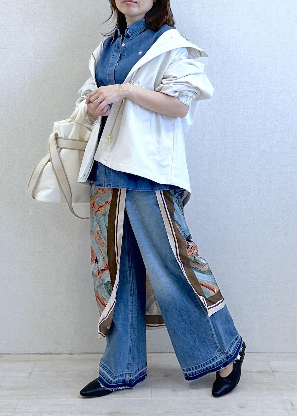 ブラック系のパンプス、ホワイト系のトートバッグ、ホワイト系のナイロンジャケットを着用したレディースの春コーディネートの9枚目の写真