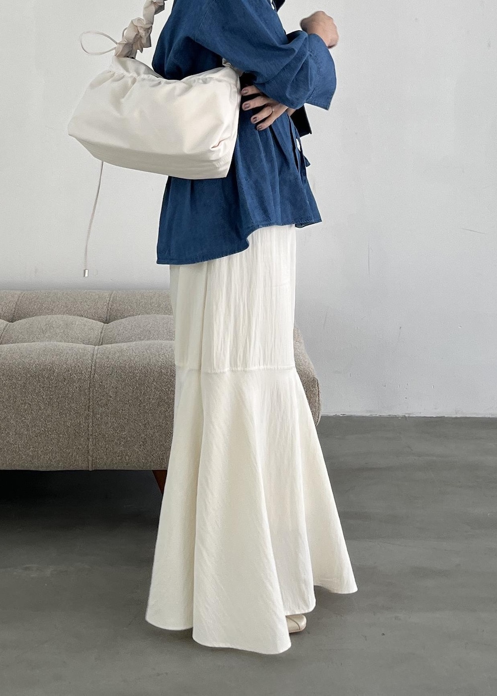 ホワイト系のショルダーバッグ、ホワイト系のパンプス、ホワイト系のスカートを着用したレディースの冬コーディネートの8枚目の写真