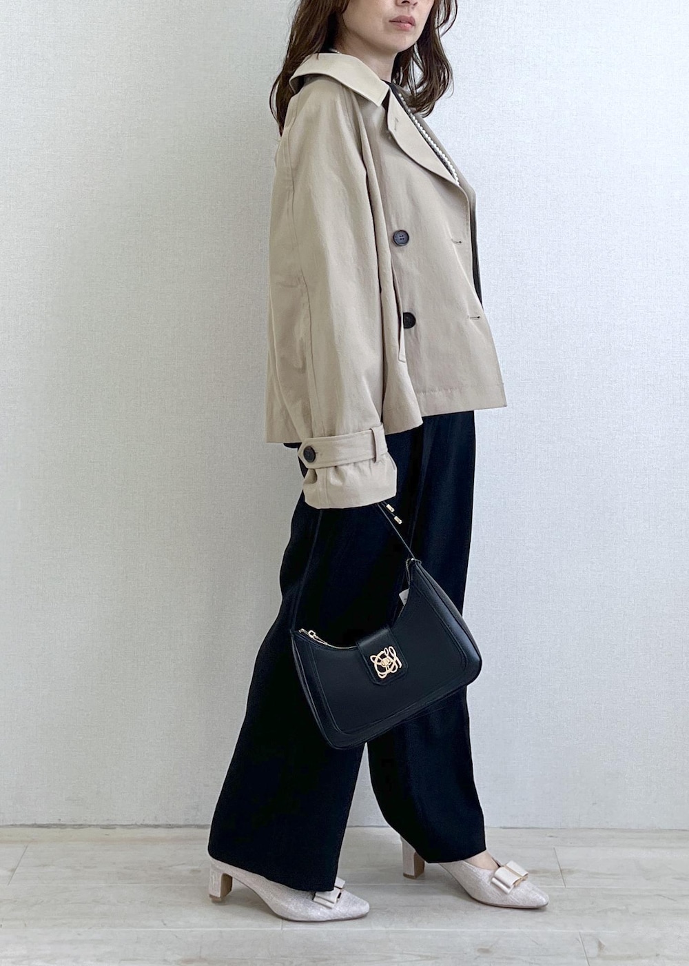 ブラック系のショルダーバッグ、ベージュ系のパンプス、ベージュ系のトレンチコートを着用したレディースの春コーディネートの3枚目の写真