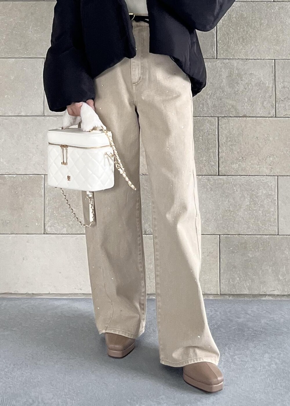 ブラック系のダウンジャケット/コート、ベージュ系のブーツ、ホワイト系のハンドバッグを着用したレディースの秋コーディネートの10枚目の写真