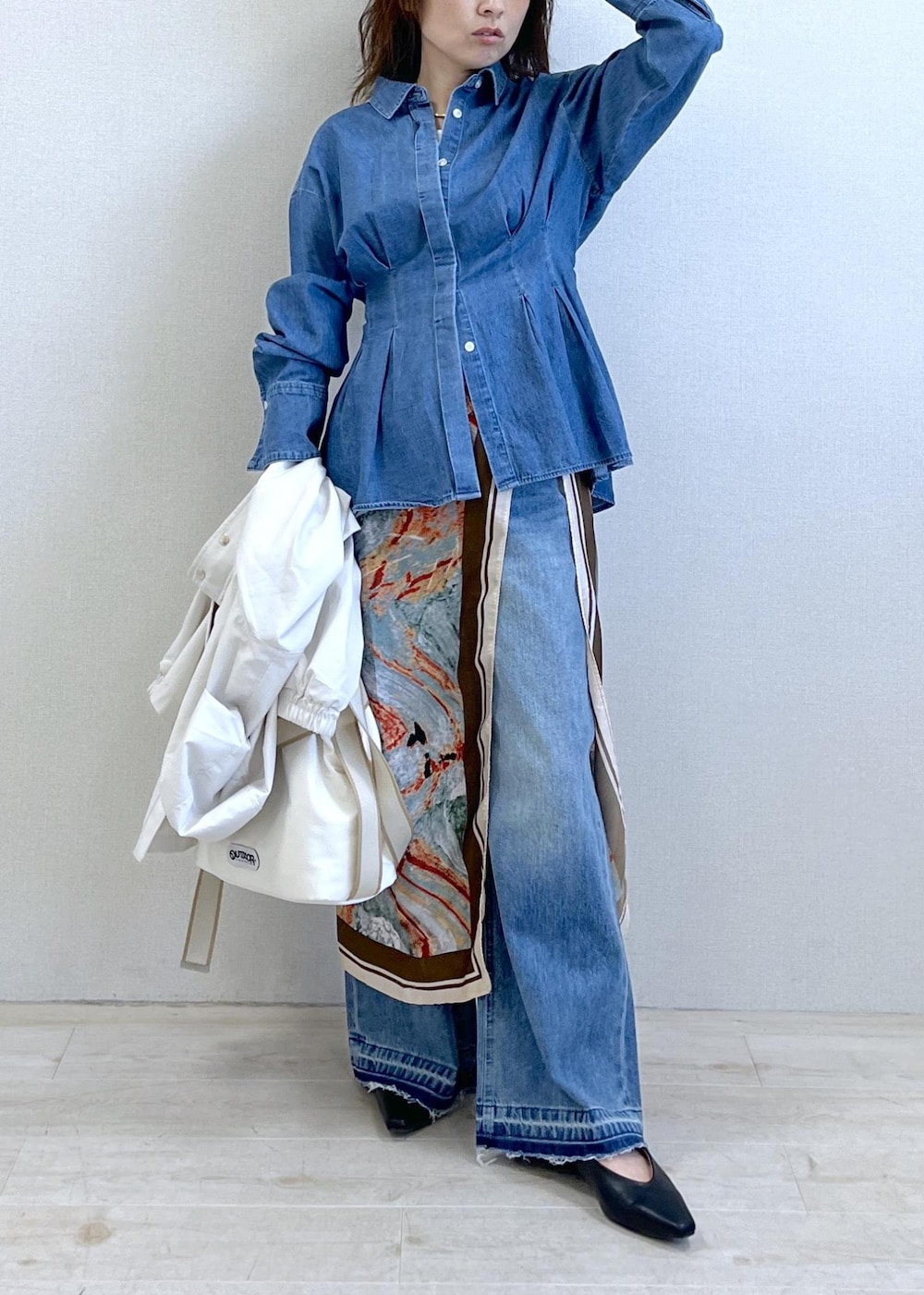 ブラック系のパンプス、ホワイト系のトートバッグ、ホワイト系のナイロンジャケットを着用したレディースの春コーディネートの2枚目の写真