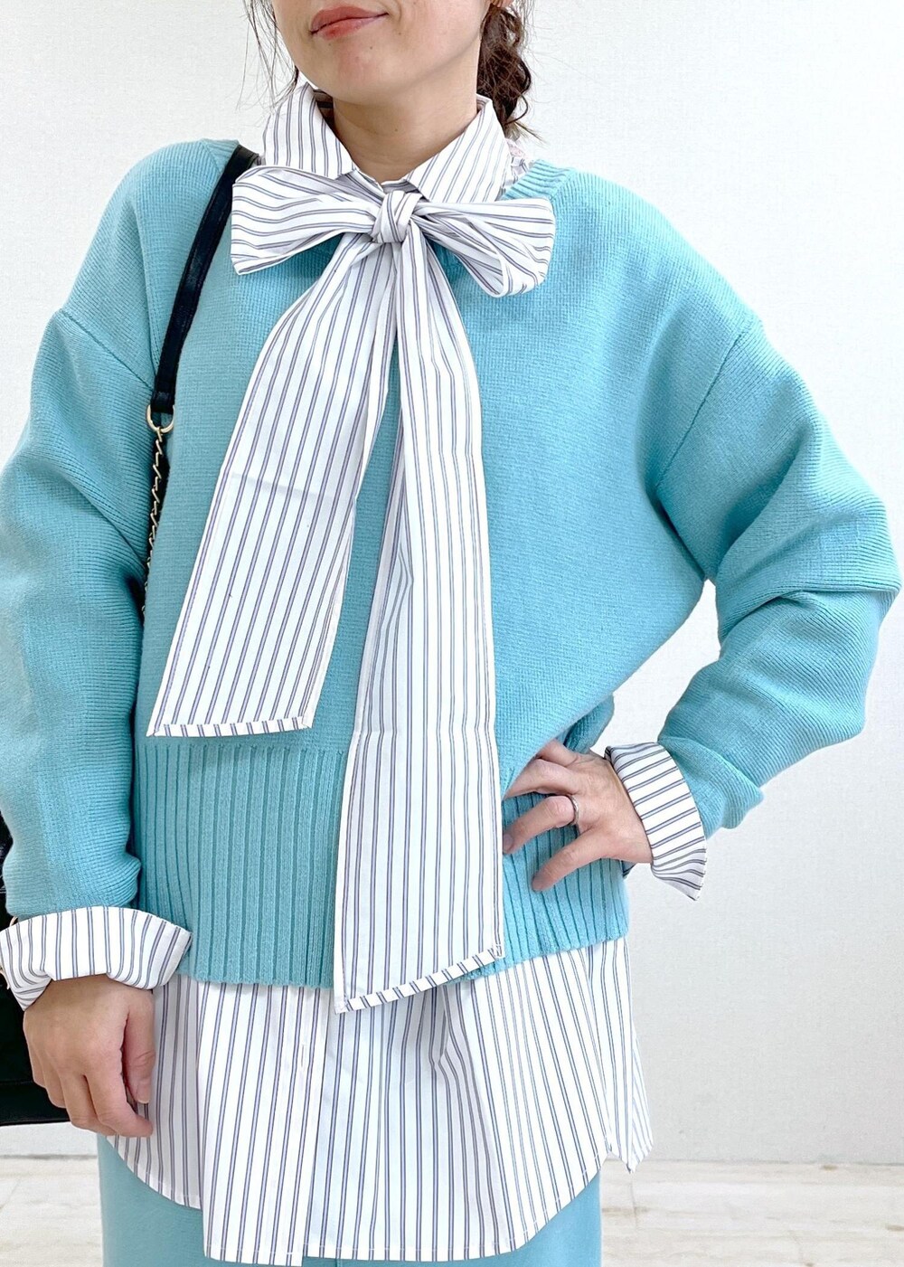 ブラック系のブーツ、ブルー系のスカート、ホワイト系のシャツ/ブラウスを着用したレディースの冬コーディネートの10枚目の写真