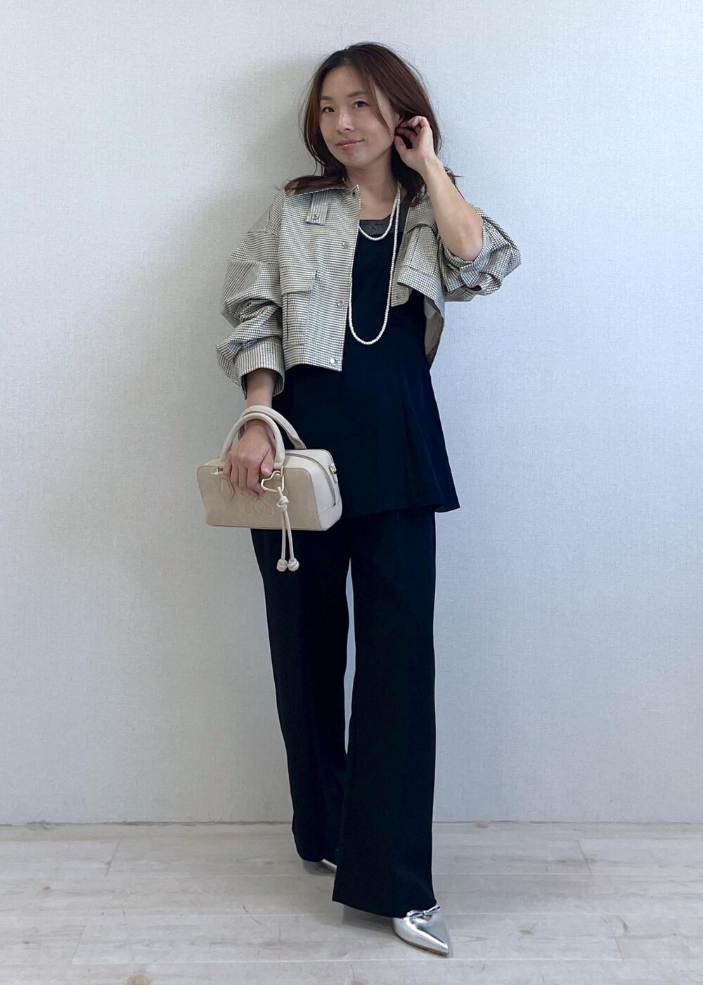 シルバー系のパンプス、ブラック系のキャミソール、ベージュ系のカバーオールを着用したレディースの秋コーディネートの6枚目の写真