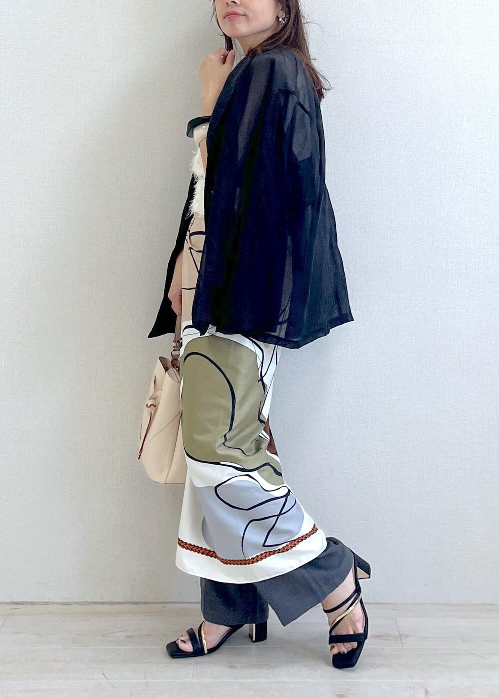 ベージュ系のショルダーバッグ、ブラック系のサンダル、ブラック系のテーラードジャケットを着用したレディースの夏コーディネートの9枚目の写真