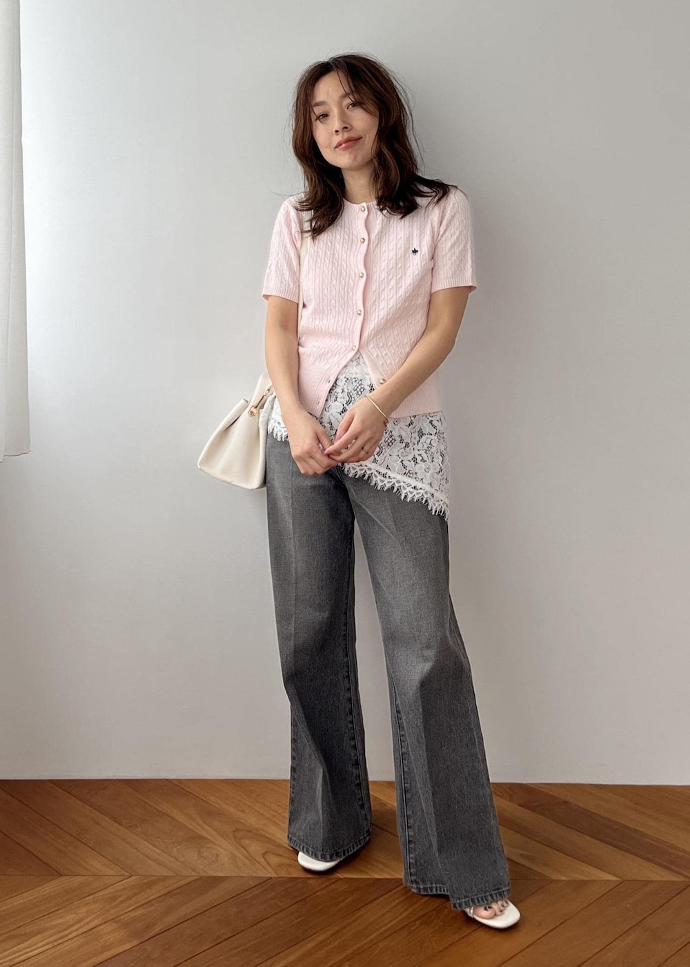 ホワイト系のキャミソール、ブラック系のデニムパンツ、ホワイト系のショルダーバッグを着用したレディースの春コーディネートの8枚目の写真