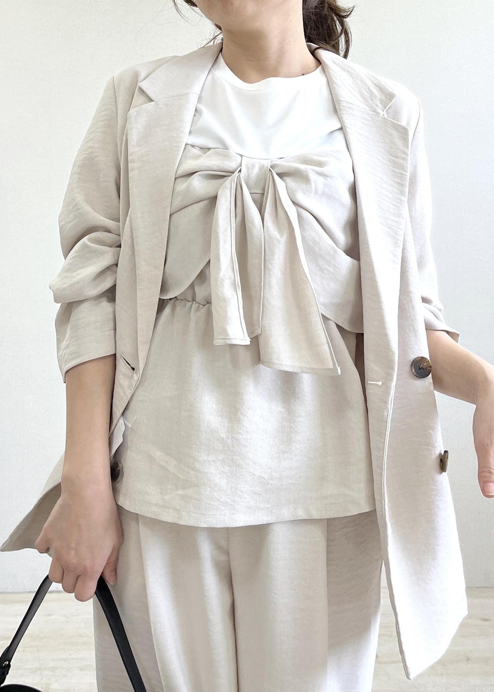 ベージュ系のパンプス、ブラック系のショルダーバッグ、ホワイト系のTシャツ/カットソーを着用したレディースの春コーディネートの5枚目の写真