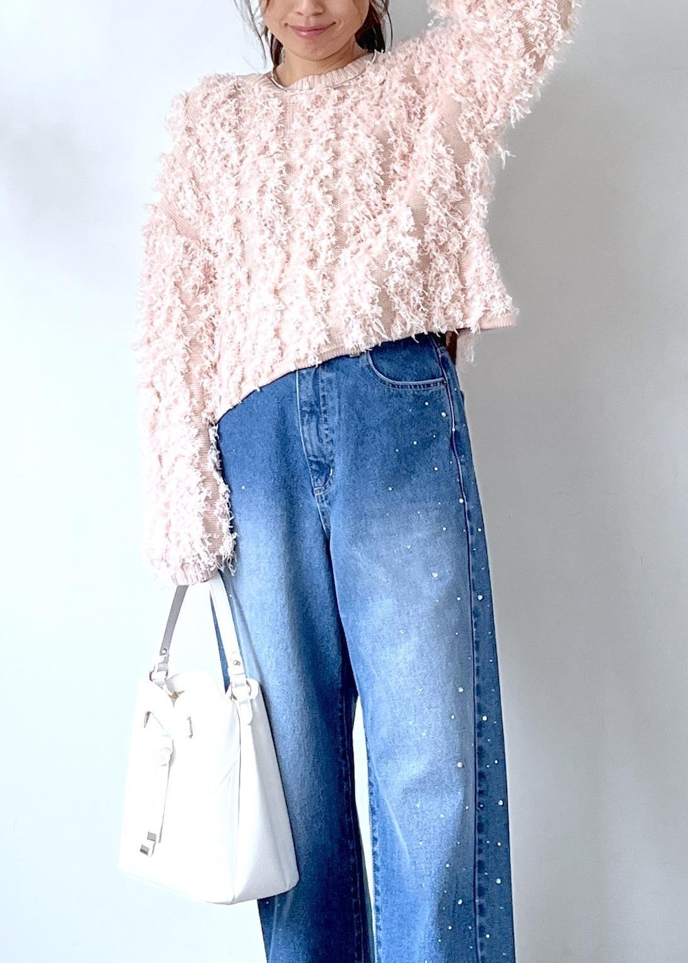 ホワイト系のショルダーバッグ、ベージュ系のブーツ、ピンク系のニット/セーターを着用したレディースの秋コーディネートの2枚目の写真