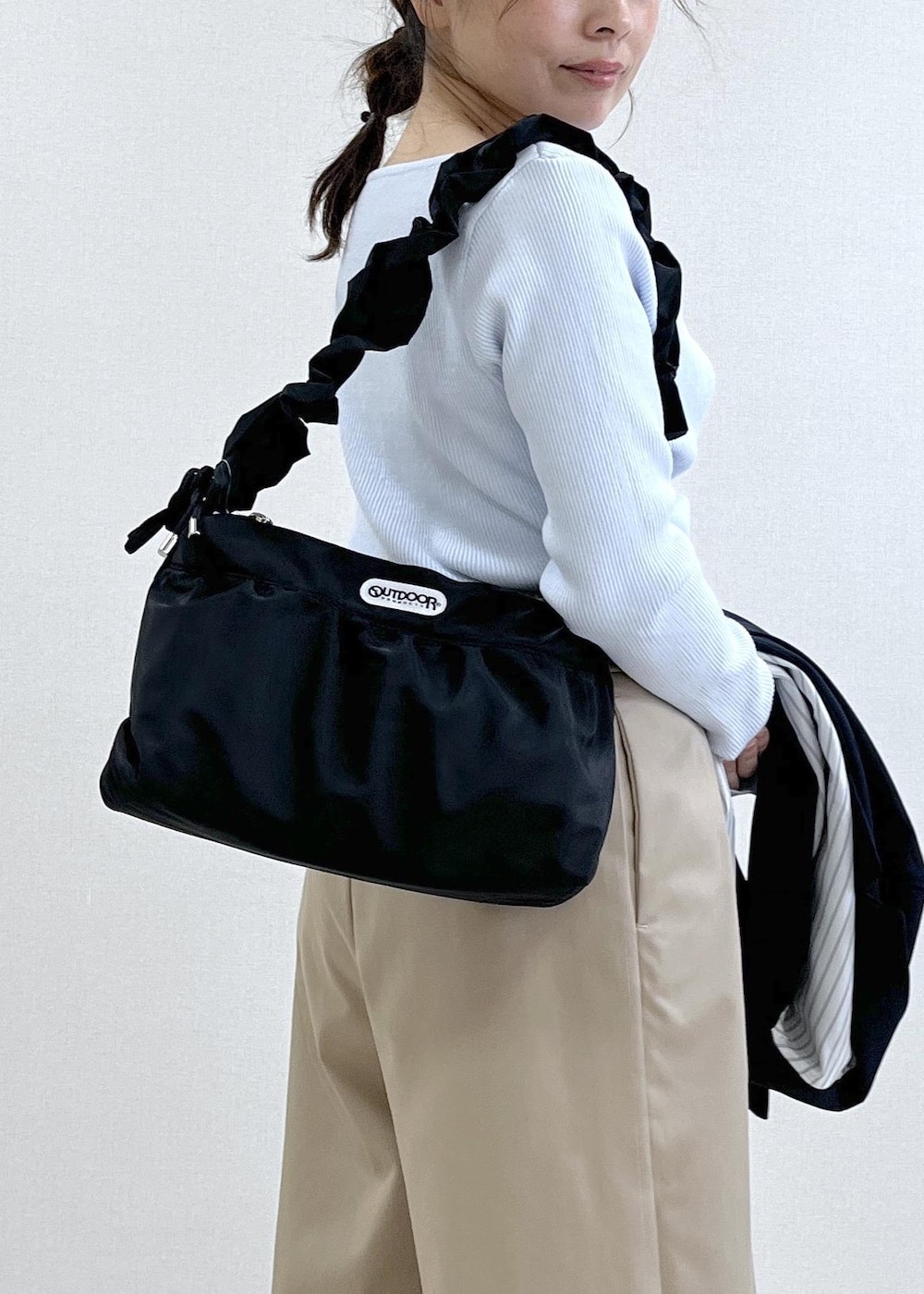 ブルー系のテーラードジャケット、ベージュ系のその他パンツ、ブラック系のショルダーバッグを着用したレディースの冬コーディネートの9枚目の写真