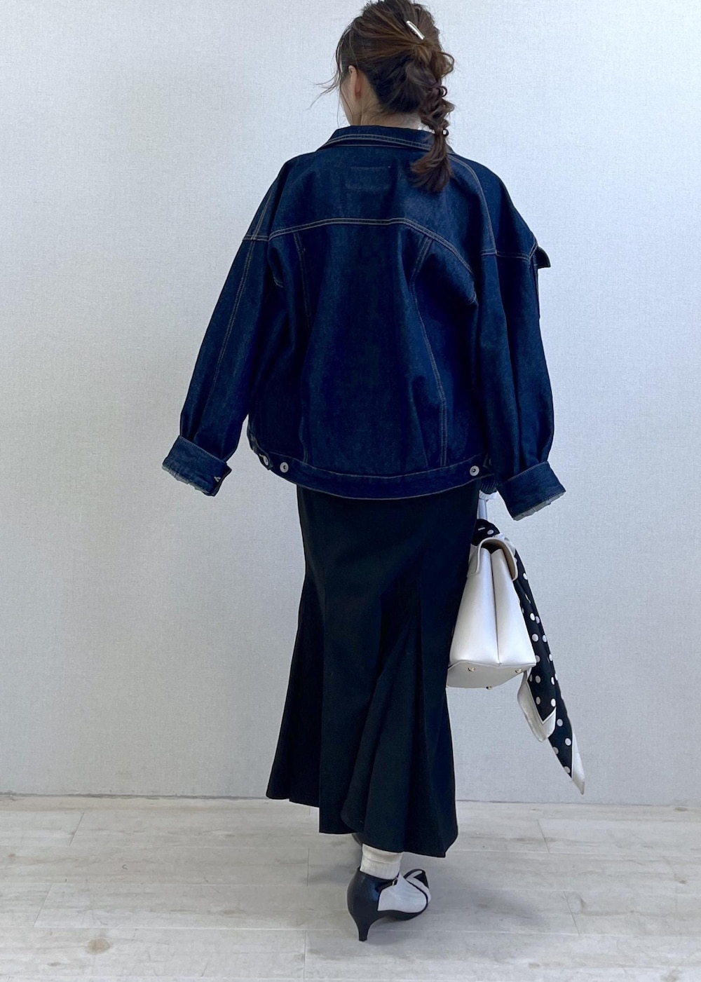 ブルー系のデニムジャケット、ブラック系のスカート、グレー系のニット/セーターを着用したレディースの冬コーディネートの4枚目の写真