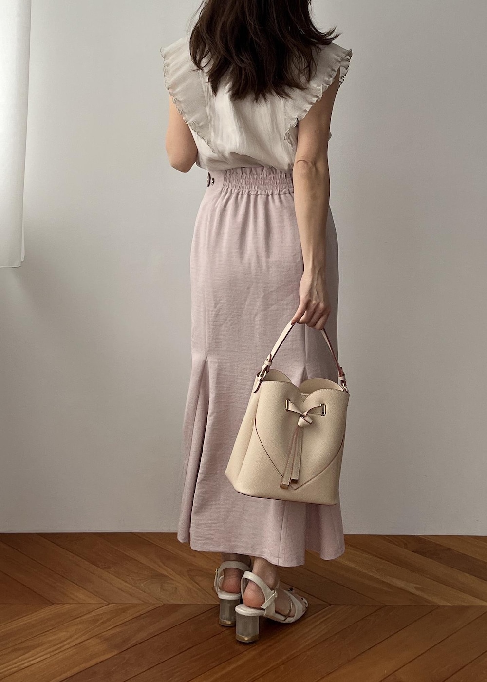 ベージュ系のショルダーバッグ、ピンク系のスカート、ホワイト系のサンダルを着用したレディースの春コーディネートの4枚目の写真
