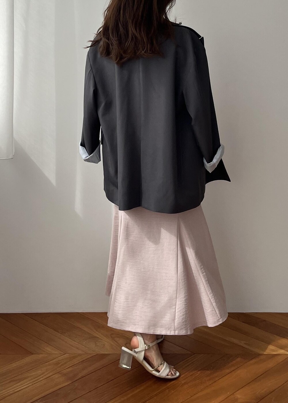 グレー系のショルダーバッグ、グレー系のテーラードジャケット、ピンク系のスカートを着用したレディースの春コーディネートの4枚目の写真