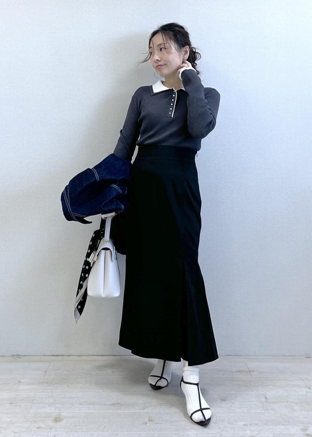 ブルー系のデニムジャケット、ブラック系のスカート、グレー系のニット/セーターを着用したレディースの冬コーディネートの5枚目の写真