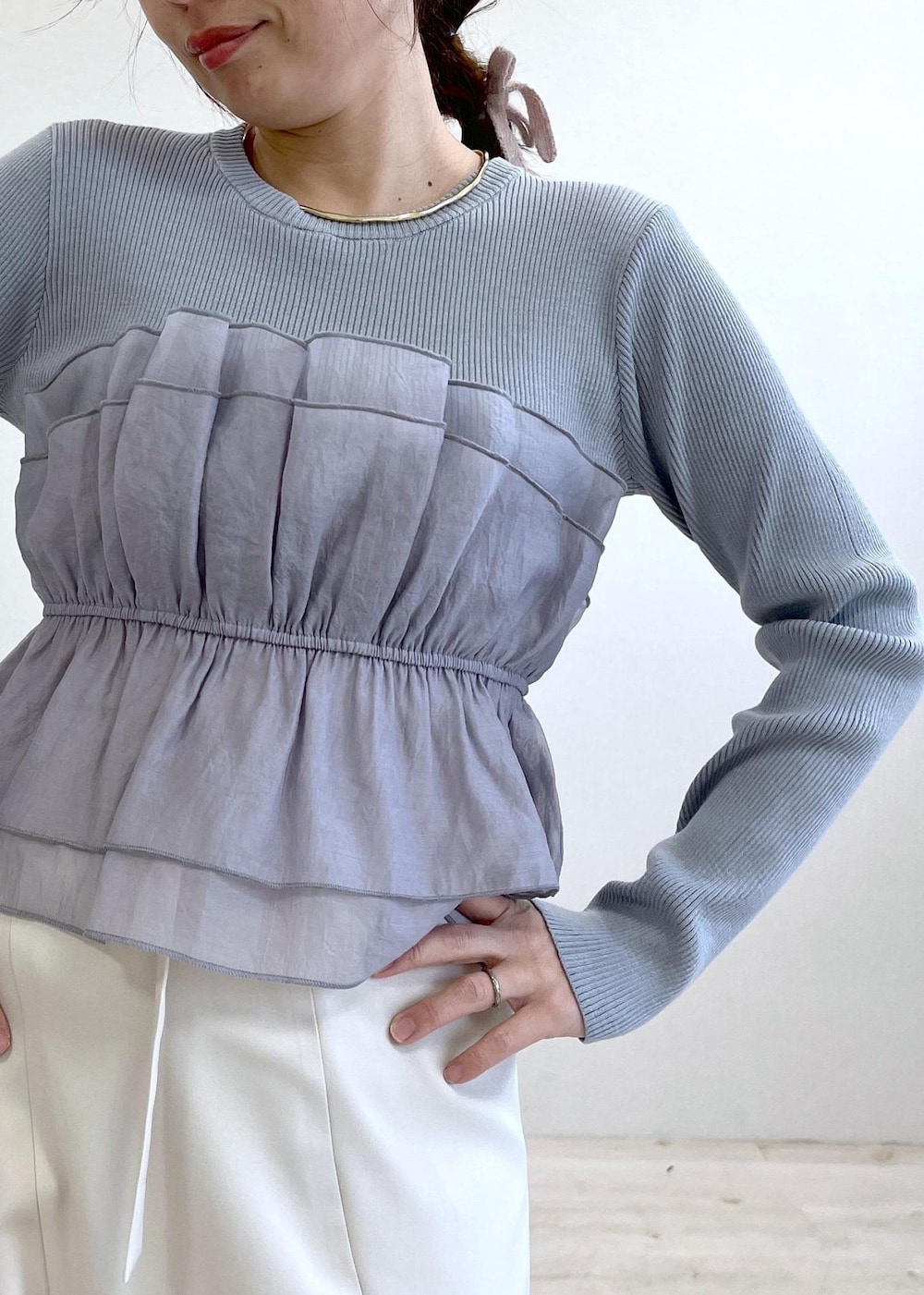 ベージュ系のショルダーバッグ、ホワイト系のバレエシューズ、ブルー系のニット/セーターを着用したレディースの春コーディネートの5枚目の写真