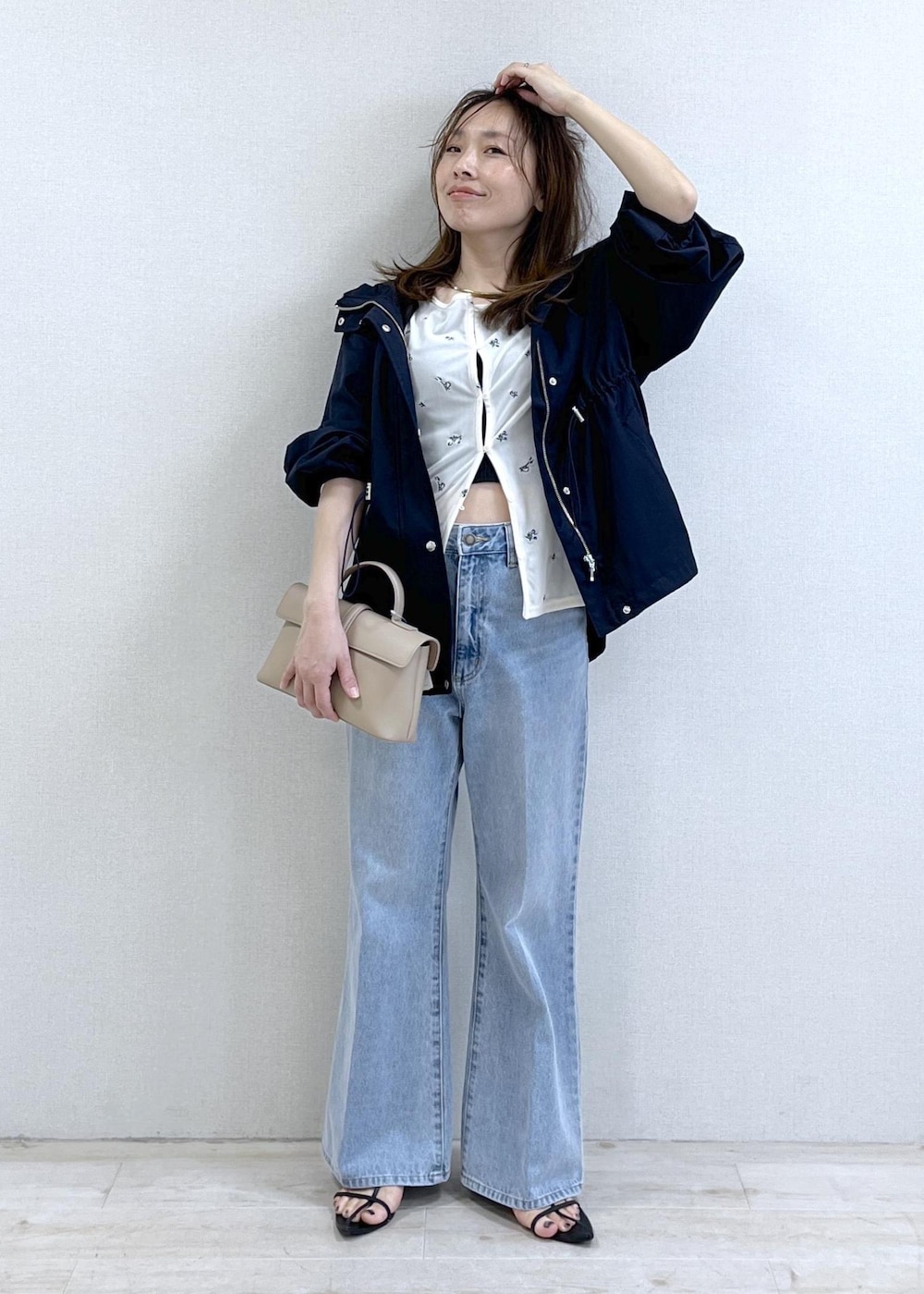 ベージュ系のショルダーバッグ、ブルー系のナイロンジャケット、ブラック系のキャミソールを着用したレディースの春コーディネートの10枚目の写真