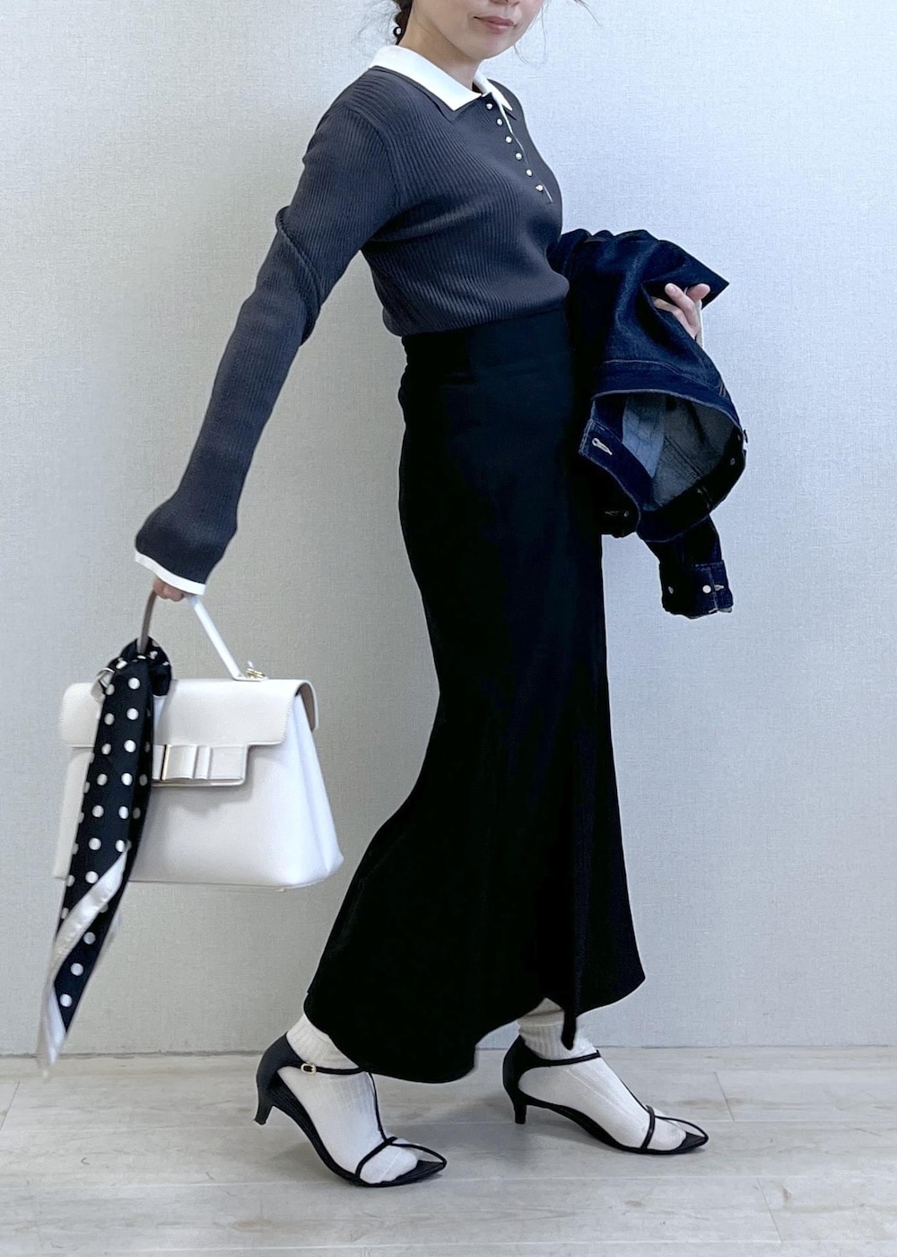 ブルー系のデニムジャケット、ブラック系のスカート、グレー系のニット/セーターを着用したレディースの冬コーディネートの7枚目の写真