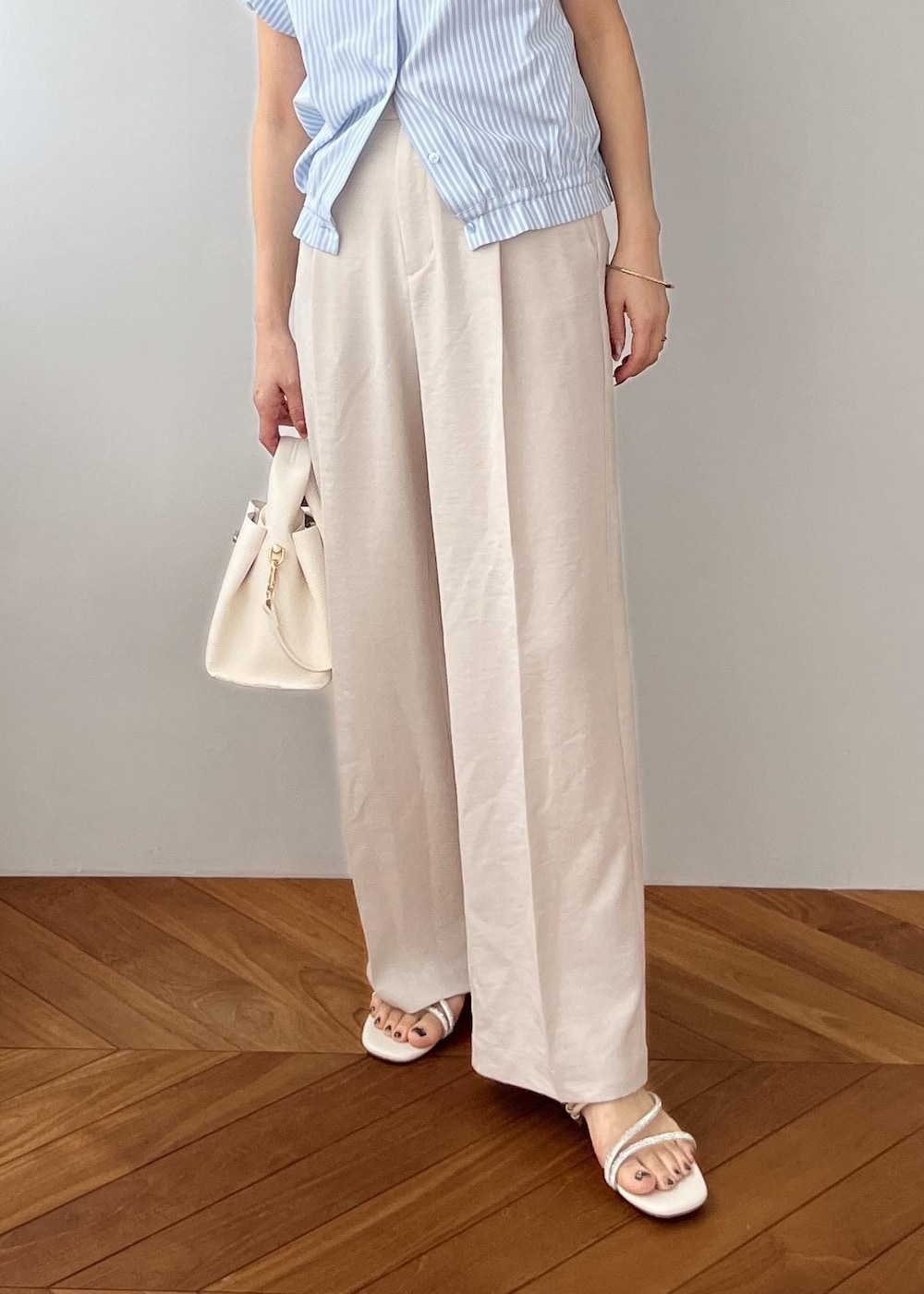 ホワイト系のその他パンツ、ホワイト系のショルダーバッグ、ホワイト系のサンダルを着用したレディースの春コーディネートの4枚目の写真
