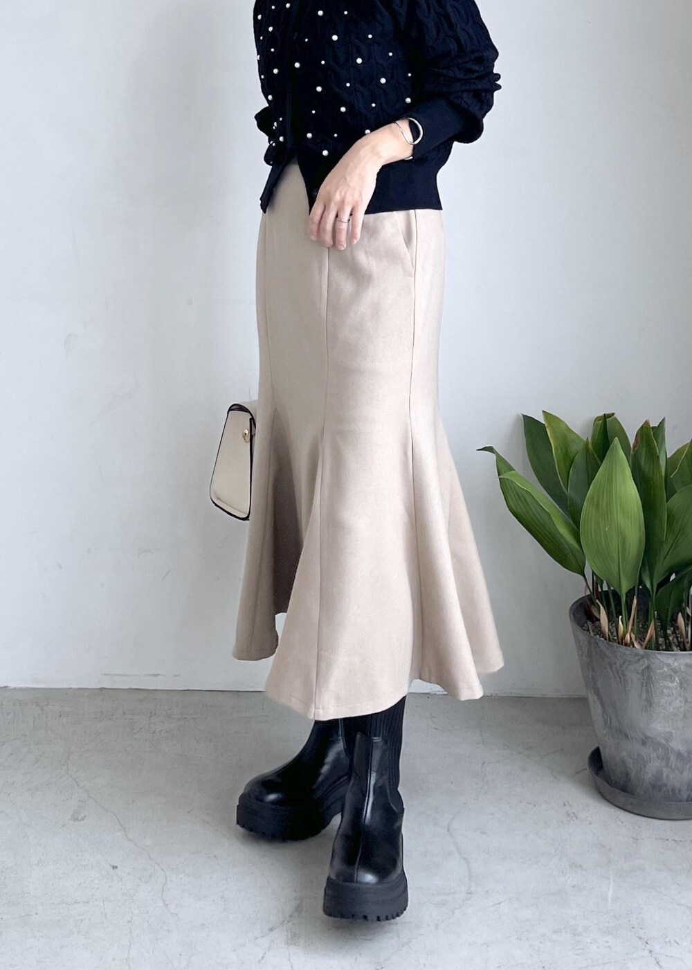ブラック系のブーツ、ベージュ系のスカート、ブラック系のカーディガン/ボレロを着用したレディースの秋コーディネートの9枚目の写真