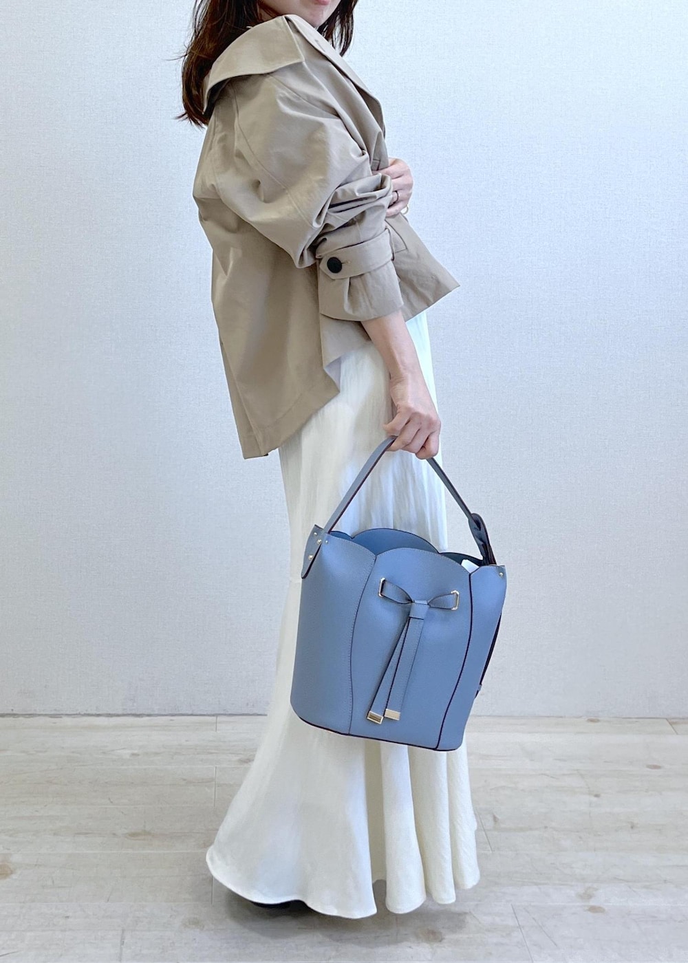 ブラック系のパンプス、ブルー系のショルダーバッグ、ベージュ系のトレンチコートを着用したレディースの春コーディネートの9枚目の写真