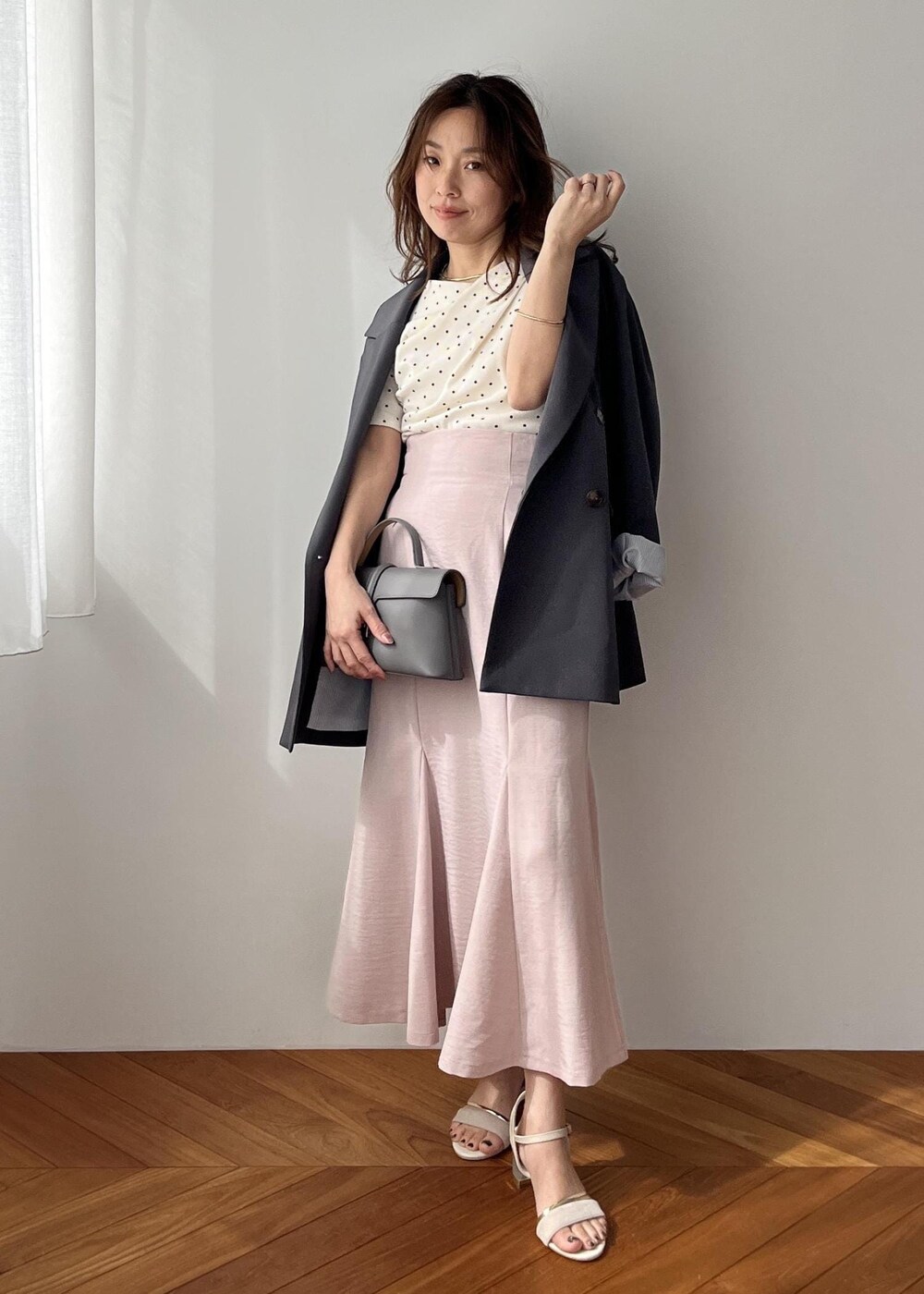 グレー系のショルダーバッグ、グレー系のテーラードジャケット、ピンク系のスカートを着用したレディースの春コーディネートの5枚目の写真